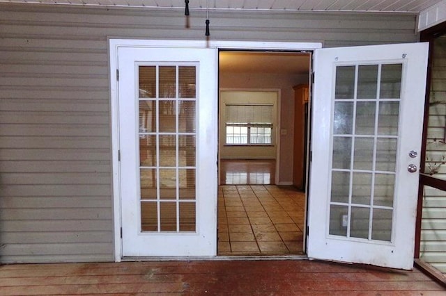 doorway to outside with wood walls