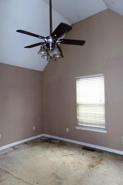 carpeted spare room with lofted ceiling and ceiling fan