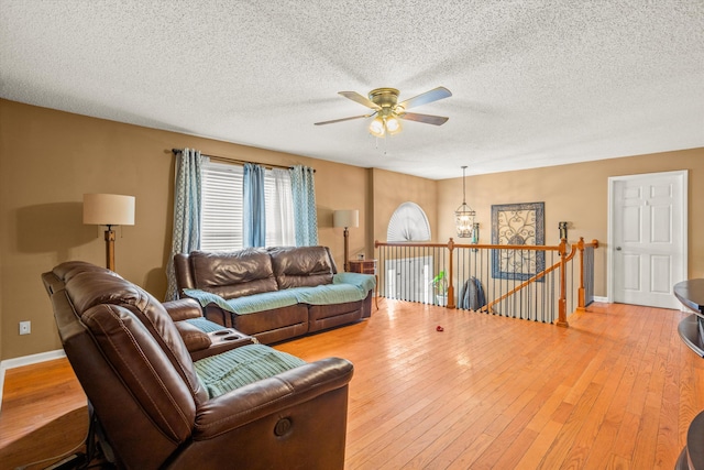 living room featuring hardwood / wood-style floors, a textured ceiling, and ceiling fan