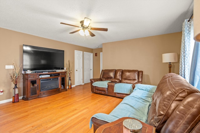 living room with ceiling fan, hardwood / wood-style floors, and a textured ceiling