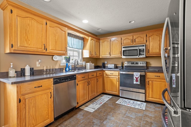 kitchen with sink, a textured ceiling, and appliances with stainless steel finishes