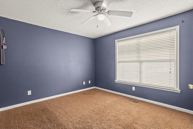 spare room featuring ceiling fan, a textured ceiling, and carpet