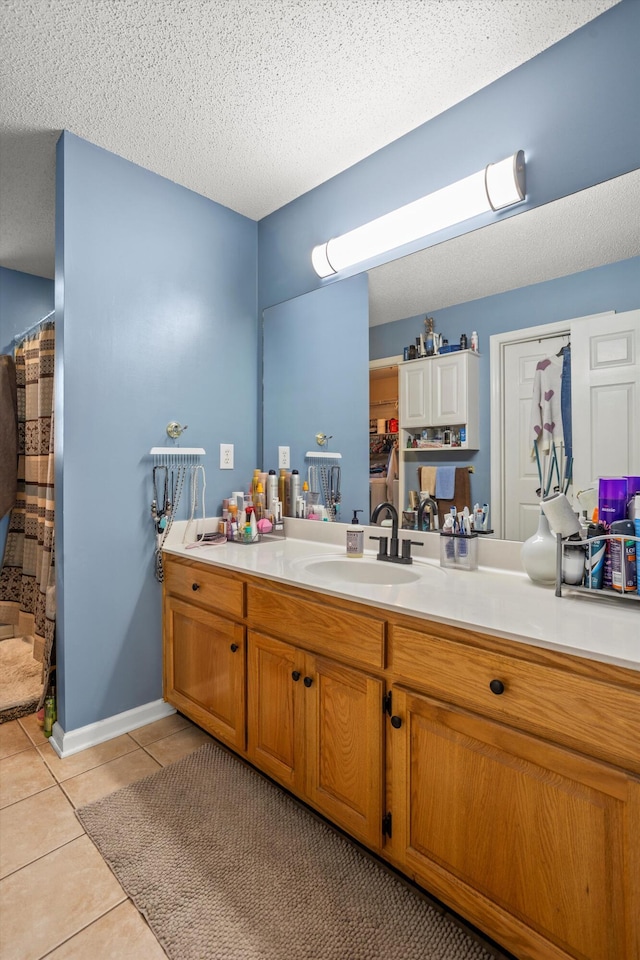 bathroom featuring tile patterned flooring, vanity, a textured ceiling, and a shower with shower curtain