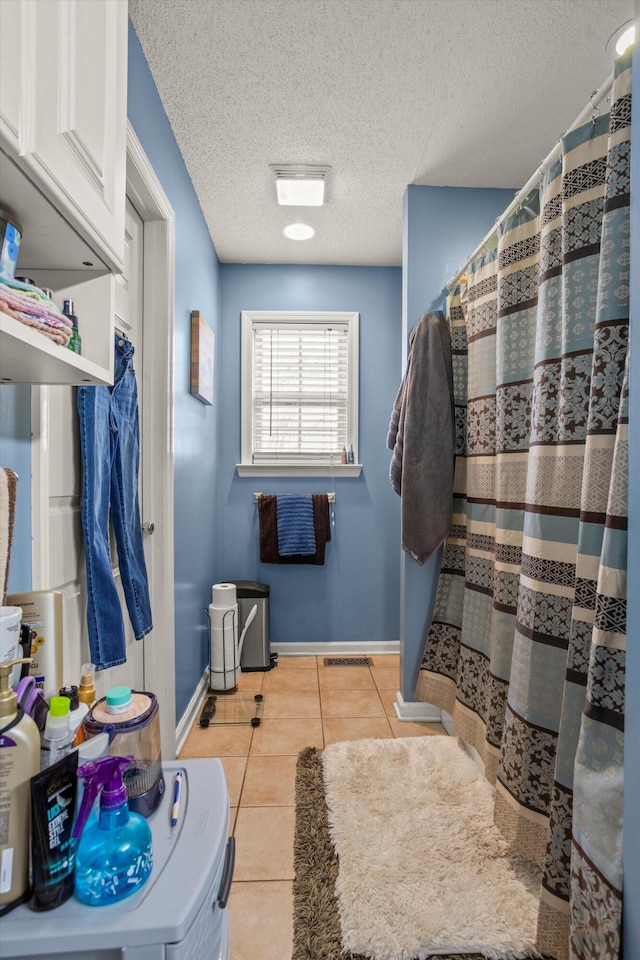 bathroom featuring tile patterned flooring and a textured ceiling