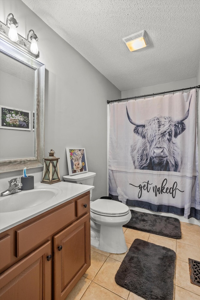 bathroom featuring vanity, tile patterned floors, a textured ceiling, and toilet