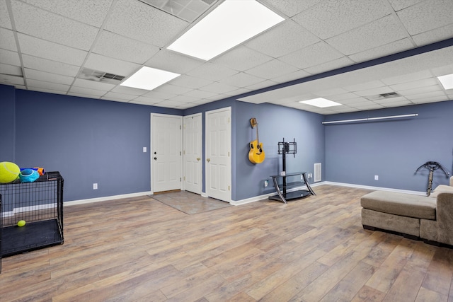 living area featuring hardwood / wood-style flooring and a drop ceiling