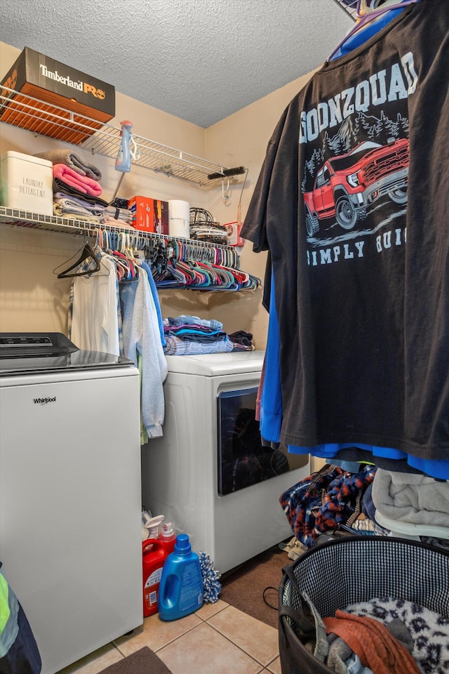 laundry area with independent washer and dryer, a textured ceiling, and light tile patterned floors