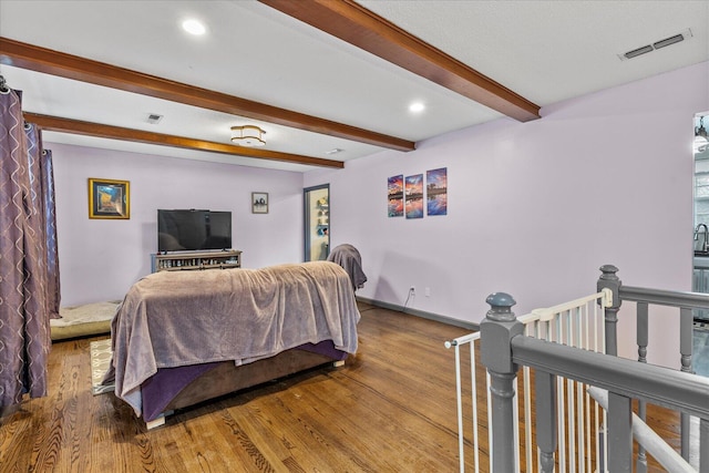 bedroom featuring beam ceiling and hardwood / wood-style flooring