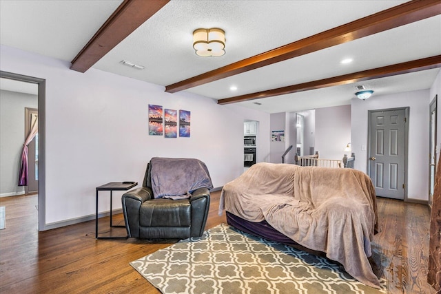 living room with beamed ceiling, hardwood / wood-style floors, and a textured ceiling