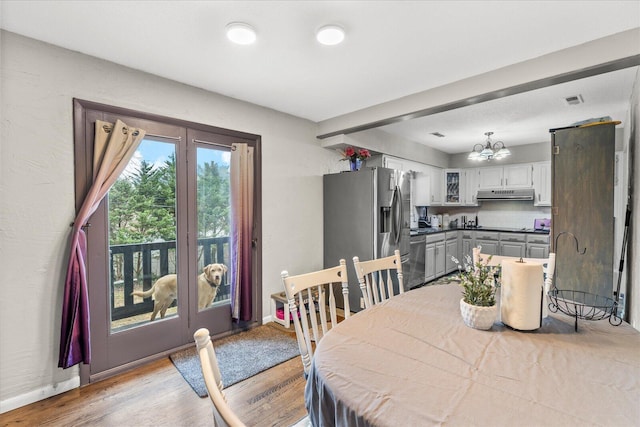 dining space with an inviting chandelier and light wood-type flooring