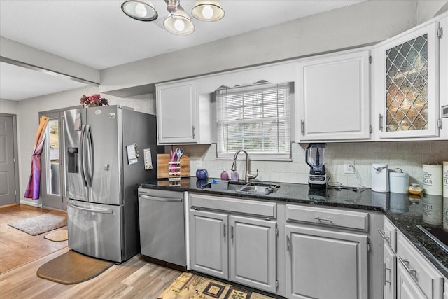 kitchen featuring tasteful backsplash, white cabinetry, sink, stainless steel appliances, and light hardwood / wood-style flooring