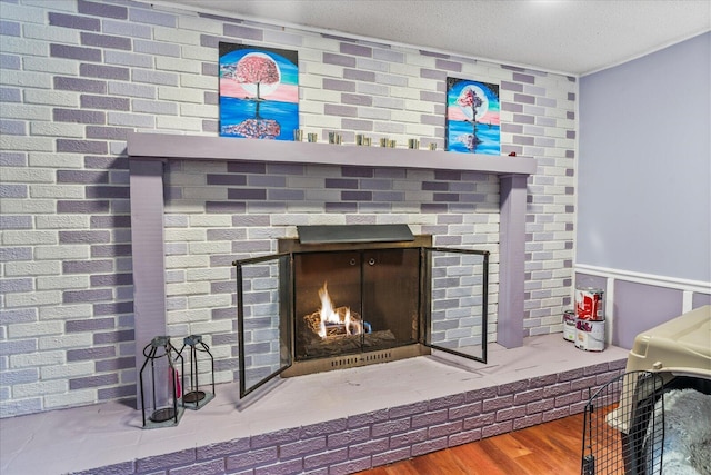 interior details with a brick fireplace, wood-type flooring, and a textured ceiling