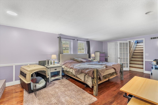 bedroom featuring wood-type flooring and a textured ceiling