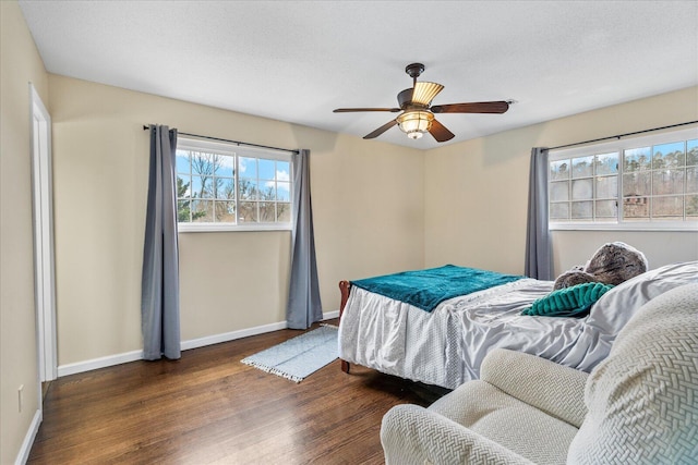 bedroom featuring ceiling fan, dark hardwood / wood-style floors, and a textured ceiling