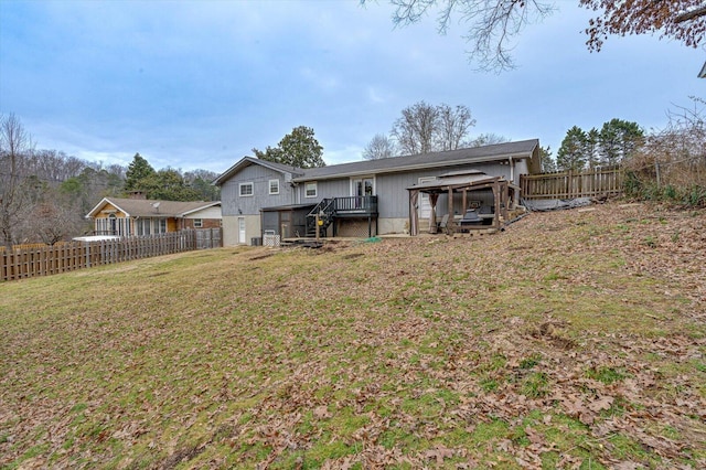 rear view of property featuring a deck and a lawn