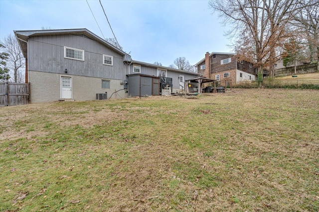 rear view of house with a gazebo, a yard, and central air condition unit