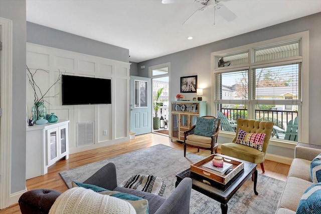 living room featuring light hardwood / wood-style flooring and ceiling fan