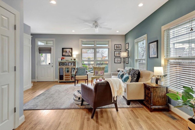 living room with ceiling fan and light hardwood / wood-style flooring