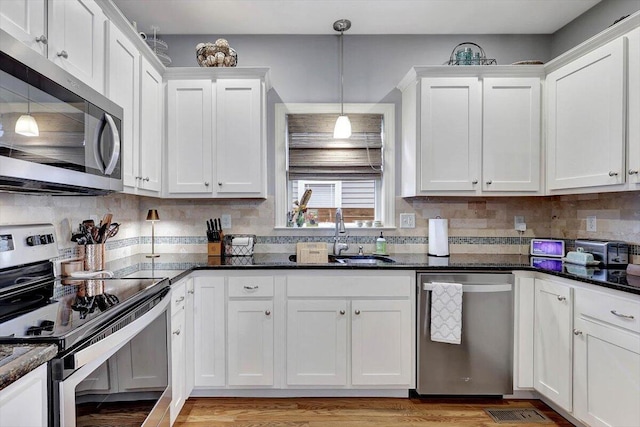 kitchen with stainless steel appliances, decorative light fixtures, sink, and white cabinets