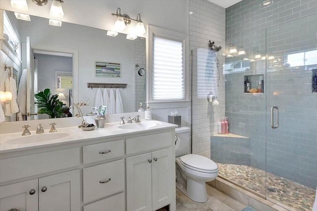 bathroom featuring a shower with door, vanity, tile patterned flooring, and toilet