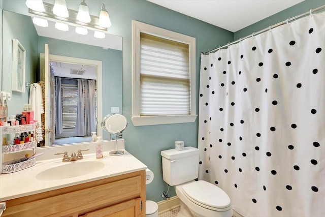 bathroom featuring vanity, walk in shower, and toilet