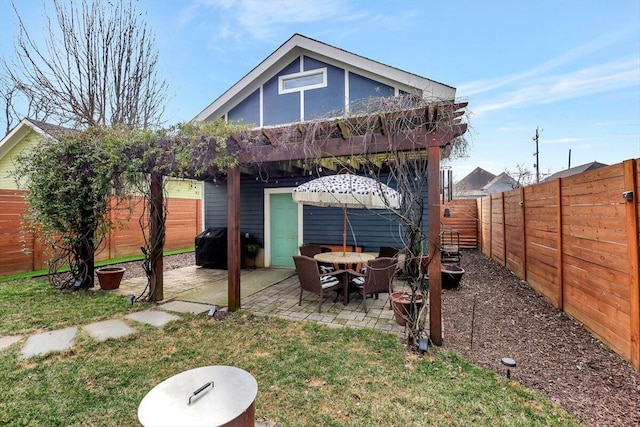 back of house featuring a pergola, a patio area, and a lawn