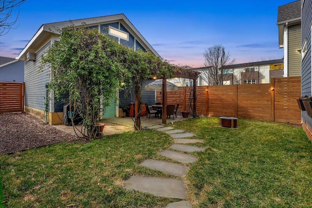 yard at dusk with a patio area