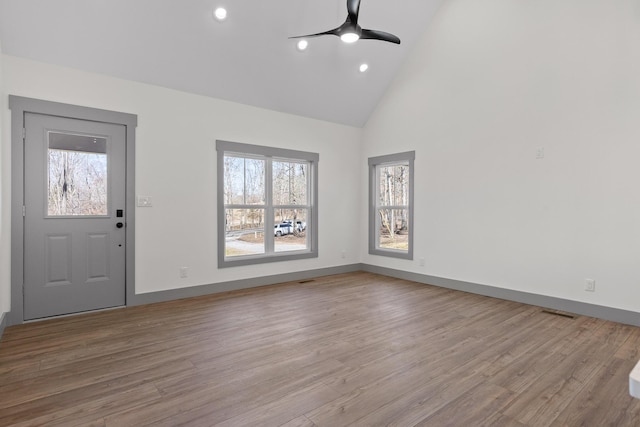 foyer entrance featuring baseboards, ceiling fan, high vaulted ceiling, and wood finished floors