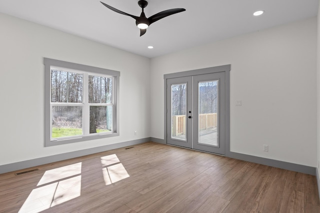 empty room with french doors, recessed lighting, visible vents, wood finished floors, and baseboards