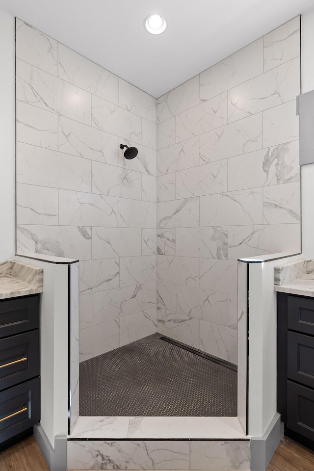 bathroom with walk in shower, wood finished floors, and vanity