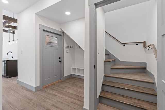 entrance foyer with light wood finished floors, baseboards, stairway, and recessed lighting