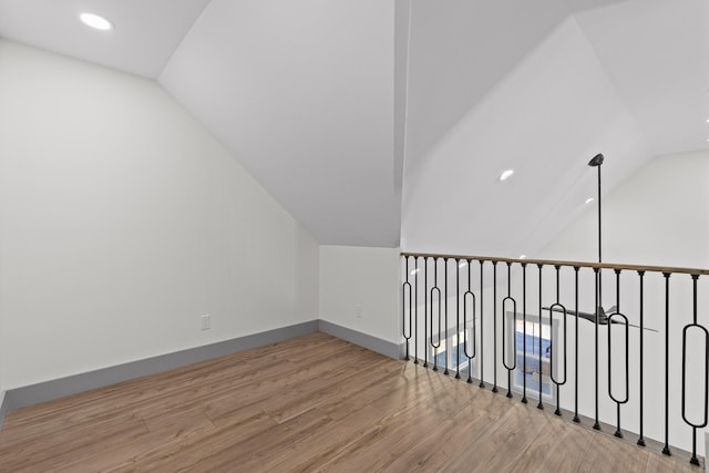 additional living space with lofted ceiling, baseboards, wood finished floors, and recessed lighting