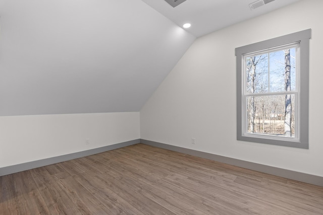 bonus room with lofted ceiling, recessed lighting, visible vents, wood finished floors, and baseboards