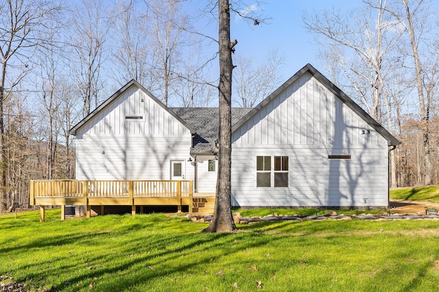 back of house featuring a shingled roof, a wooden deck, board and batten siding, and a yard