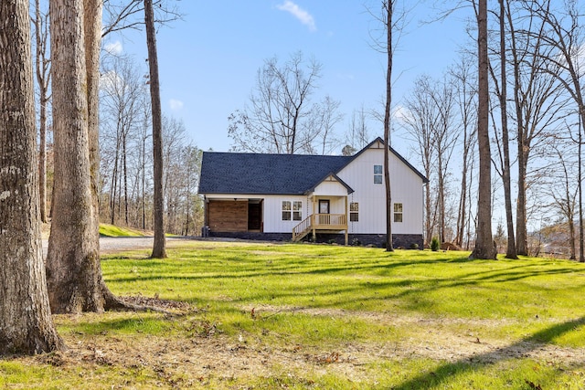 view of front of house with a shingled roof and a front lawn