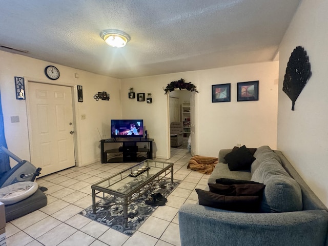 tiled living room featuring a textured ceiling