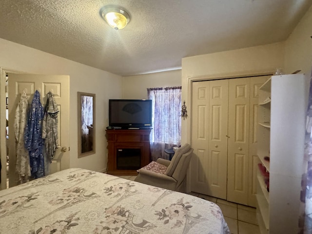 bedroom featuring tile patterned floors, a closet, and a textured ceiling