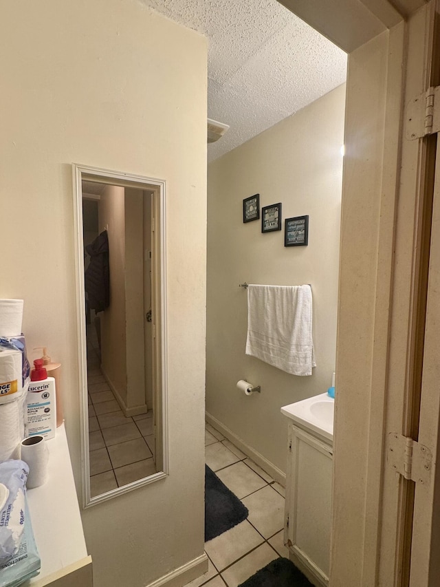 bathroom featuring vanity, tile patterned floors, and a textured ceiling