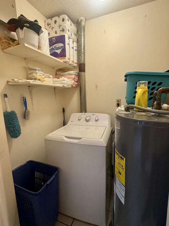 laundry area featuring tile patterned flooring, washer / dryer, water heater, and a textured ceiling