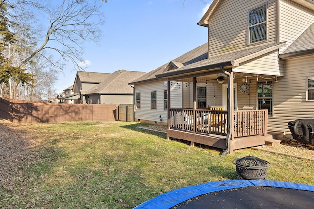 back of house with a wooden deck, ceiling fan, a yard, and a fire pit