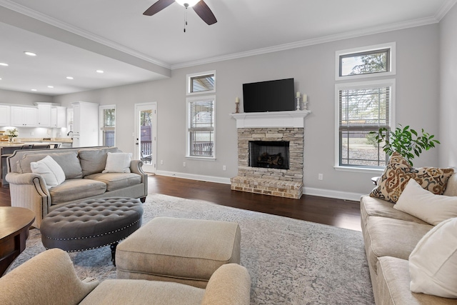 living room with crown molding, a stone fireplace, ceiling fan, and dark hardwood / wood-style flooring