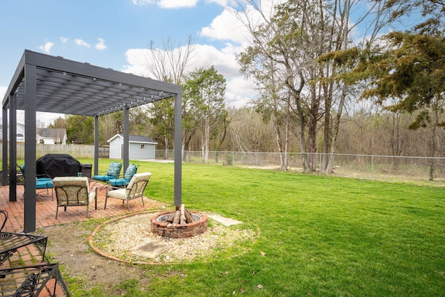 view of yard with a shed, a pergola, and an outdoor fire pit