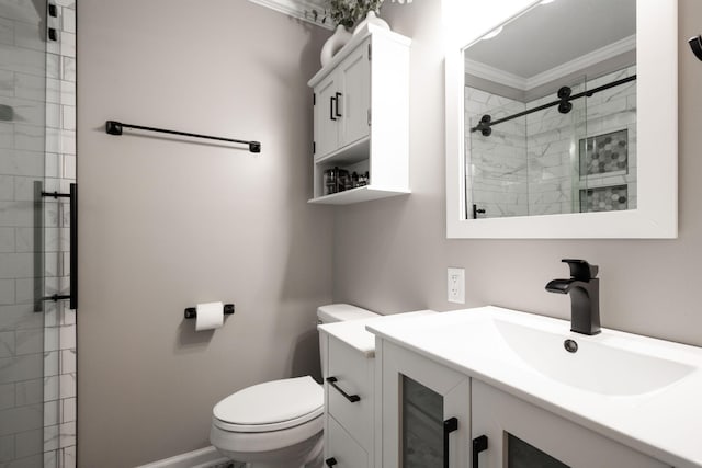 bathroom with vanity, tiled shower, ornamental molding, and toilet