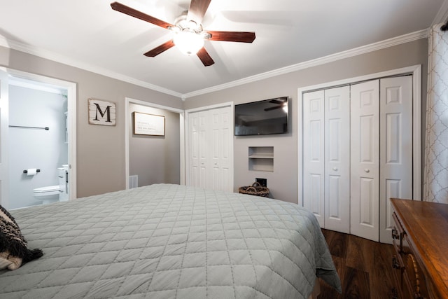 bedroom featuring hardwood / wood-style floors, ornamental molding, and two closets