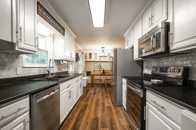 kitchen featuring sink, appliances with stainless steel finishes, dark hardwood / wood-style floors, decorative backsplash, and white cabinets