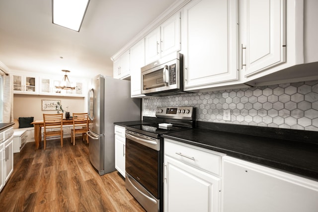 kitchen featuring hanging light fixtures, stainless steel appliances, tasteful backsplash, white cabinets, and dark hardwood / wood-style flooring