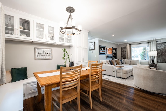 dining area featuring dark hardwood / wood-style flooring, ornamental molding, and a chandelier