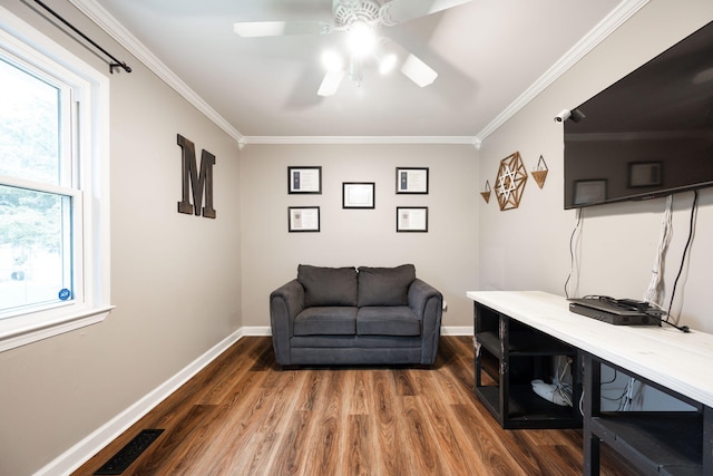 living area featuring crown molding, hardwood / wood-style floors, and ceiling fan