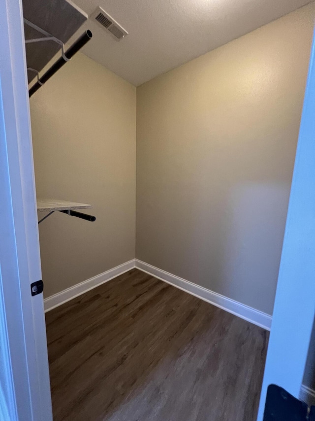 walk in closet with dark hardwood / wood-style flooring