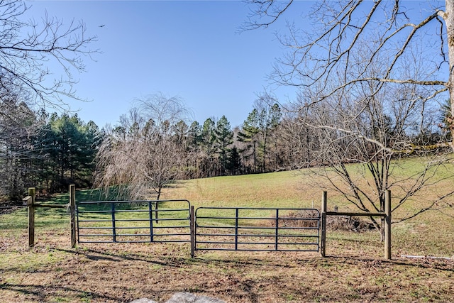 view of gate featuring a yard and a rural view